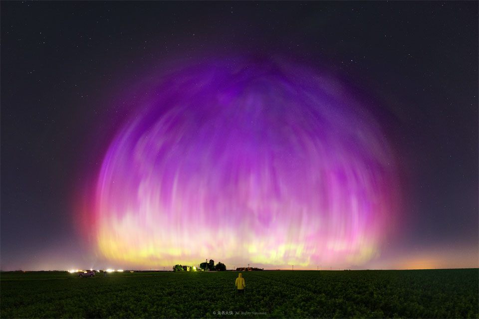 
A large purple transparent dome appears to cover much of a starry
sky. A person stands in a field looking toward the unusual spectacle.
Więcej szczegółowych informacji w opisie poniżej.